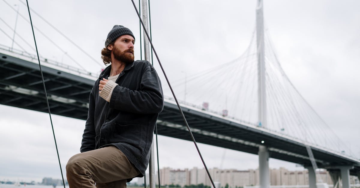 What to consider for a last-minute impromptu trip to northern Sweden? - Man in Black Jacket and Brown Pants Sitting on Gray Metal Ladder