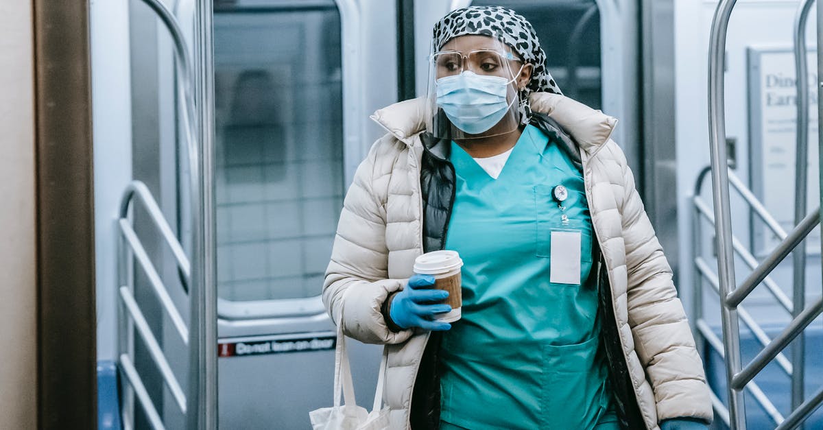 What to do if a mail-to-home train ticket is estimated to arrive after you leave? - Emotionless African American female doctor in uniform and outerwear wearing protective mask and face shield leaving metro train during coronavirus pandemic