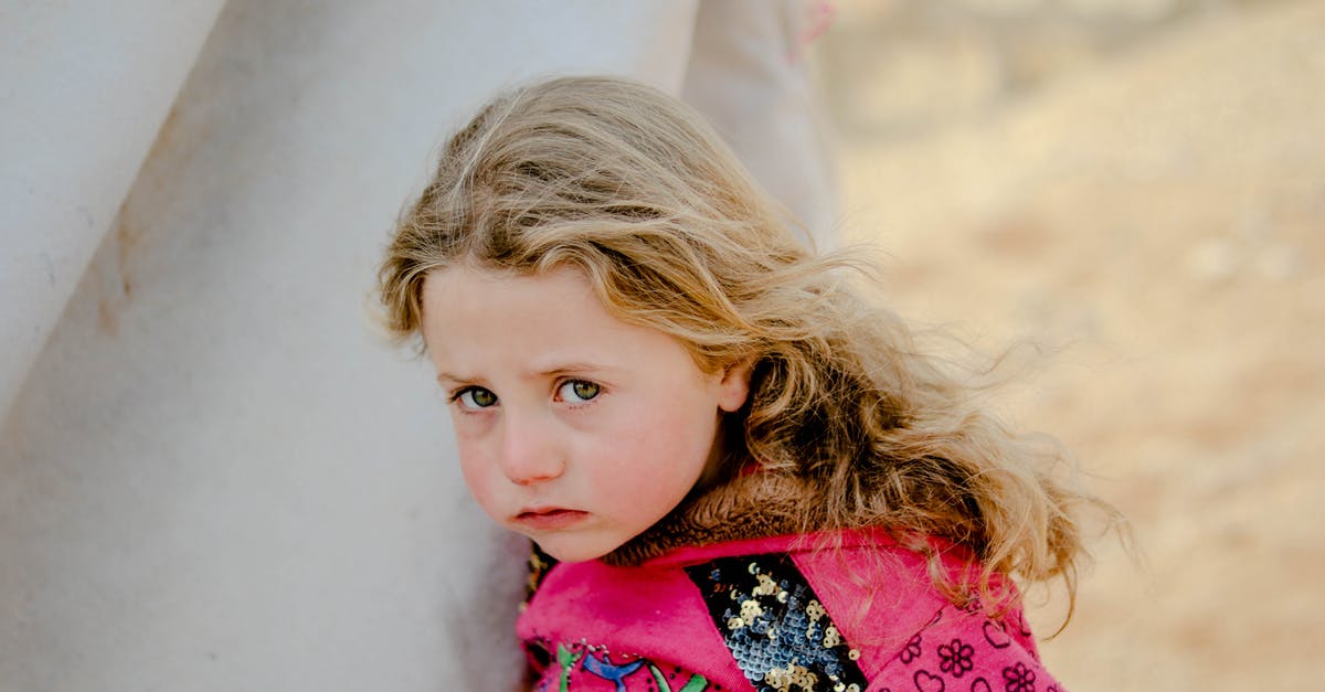 What to do if you need to fly in the Schengen area and lose your ID card? - Unhappy little girl looking at camera while standing near weathered shelter in poor refugee camp on blurred background of countryside