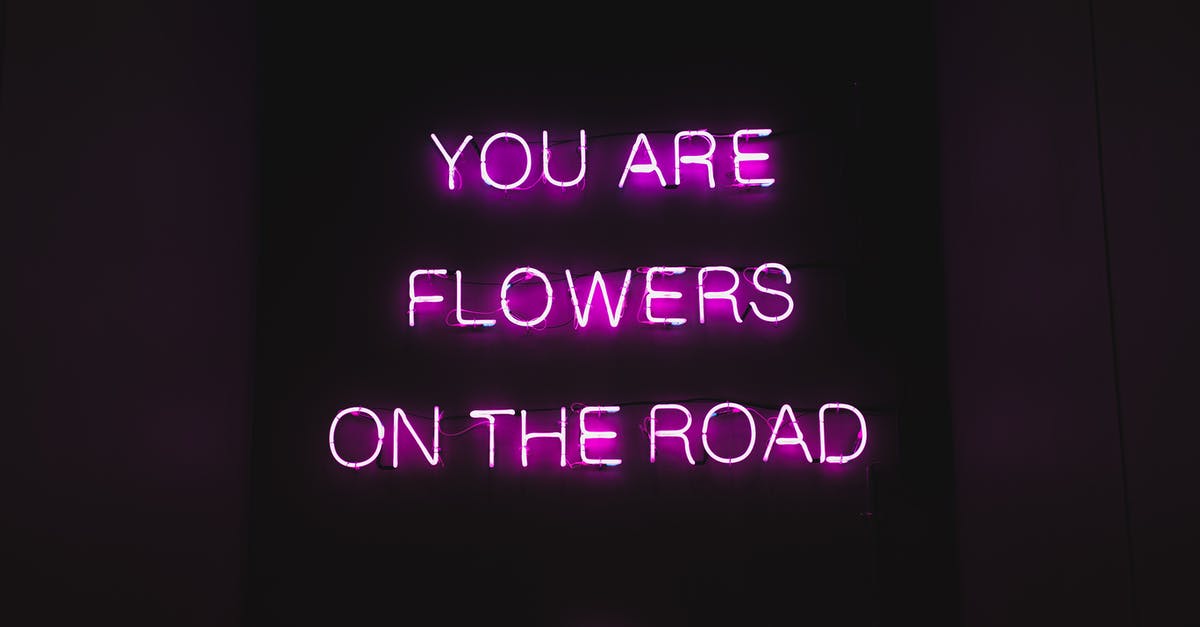 What to do when you can't print your boarding pass? - Pink color neon luminous text with inspiring phrase You are flowers on the road on black signage at night