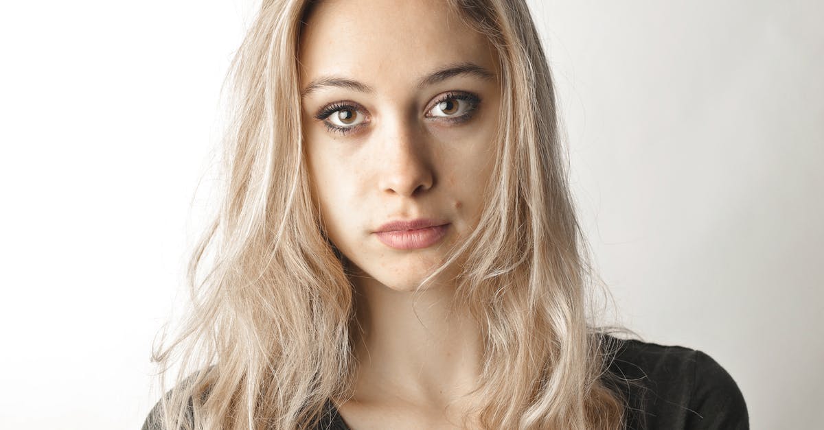 What to do with long facial hair in the onsen? - Woman in Gray Shirt Standing Beside White Wall