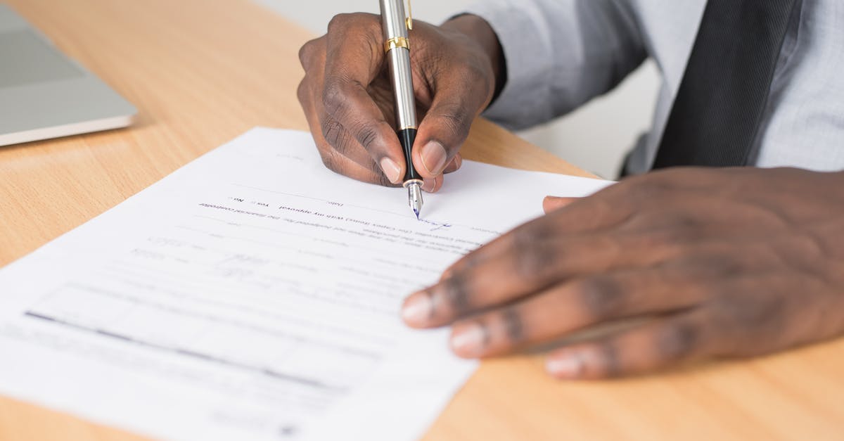What to write in visa application form and what documents to submit as an unregistered freelancer? - Person Holding Gray Twist Pen and White Printer Paper on Brown Wooden Table