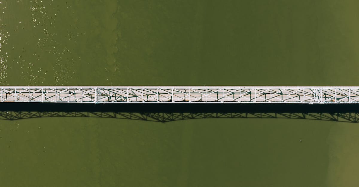 What truly cross-continental train trips still exist? - Aerial top view of modern motor bridge crossing vast rippling river on sunny day