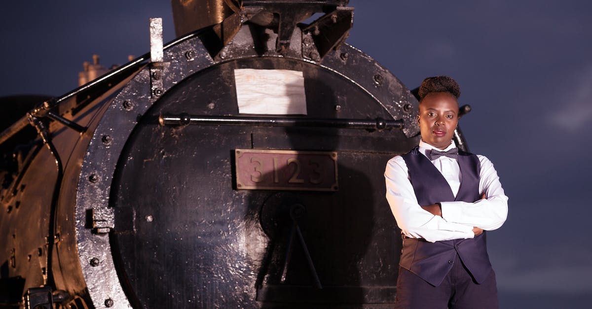 What truly cross-continental train trips still exist? - Boy in White Dress Shirt and Black Pants Standing on Black Metal Wheel