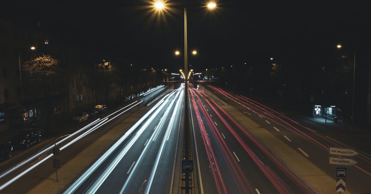 What’s the proper lane for going straight through a traffic light when formal lines don’t exist? [closed] - Long exposure cars driving on multiple lane  road in suburb at night
