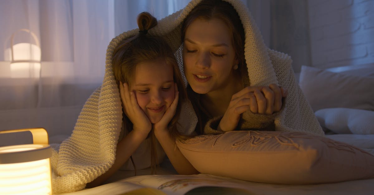 When's the best time to fly with kids [closed] - Mother and Daughter Lying on Bed while Reading a Book