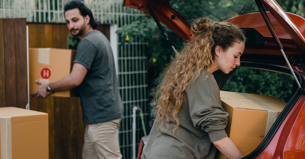 When and where can I buy alcohol in New Caledonia? - Young couple unpacking car in yard of new house