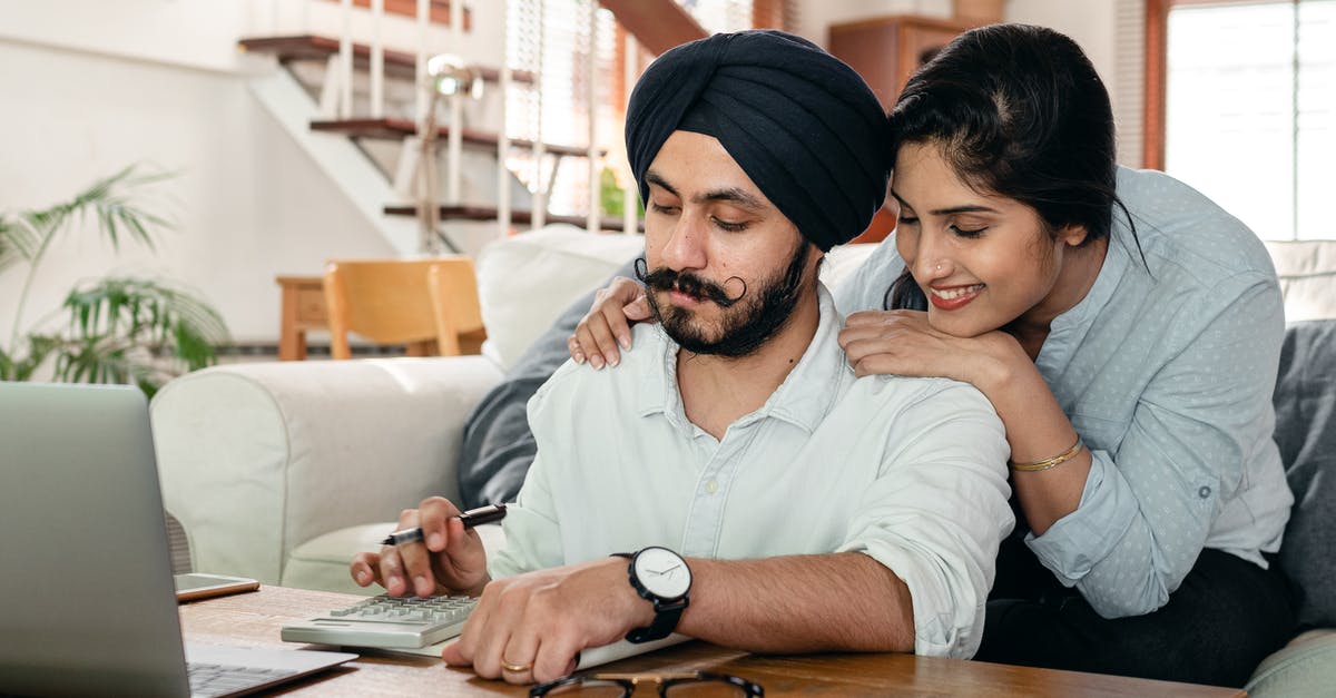 When are alliance frequent flier accounts mutually supported? - Cheerful ethnic couple using calculator while sitting at table