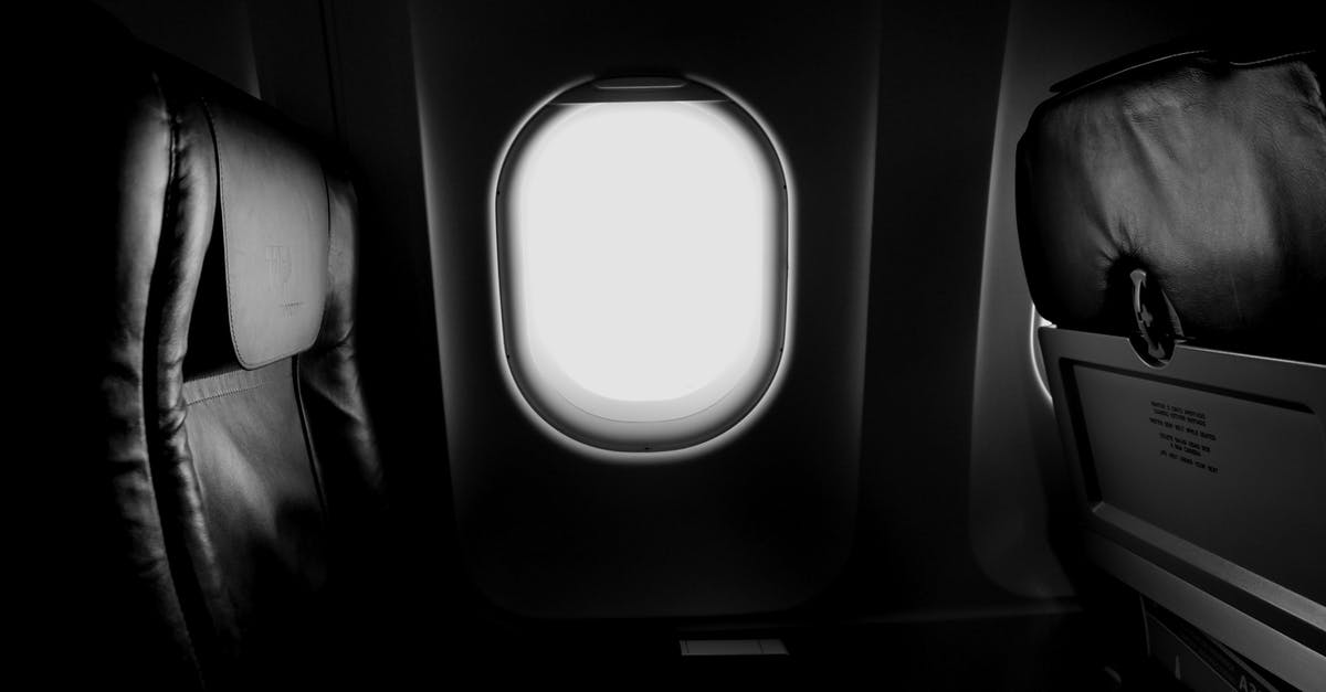 When is it that you can't reserve a specific seat on a plane beforehand? - Grayscale of Airplane Window and Chair