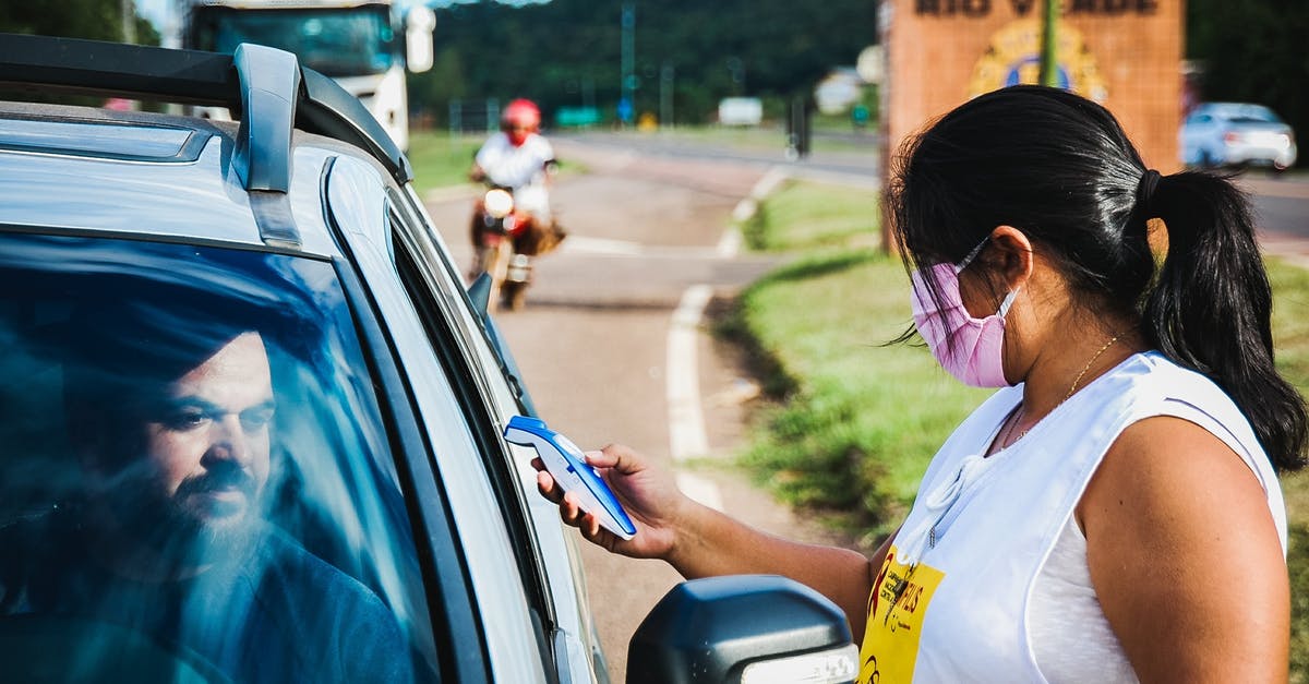 When obtaining gender reassignment/plastic surgery overseas, is an emergency travel document required to return home? - Woman in White Shirt Holding Smartphone When obtaining gender reassignment/plastic surgery overseas, is an emergency travel document required to return home? - Woman in White Shirt Holding Smartphone