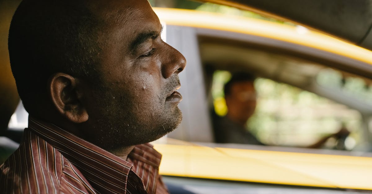 When picking a "luxury hostel" for a business trip, how to ensure it'll be quiet enough? - Side view of contemplative adult ethnic male cab driver looking forward while driving transport