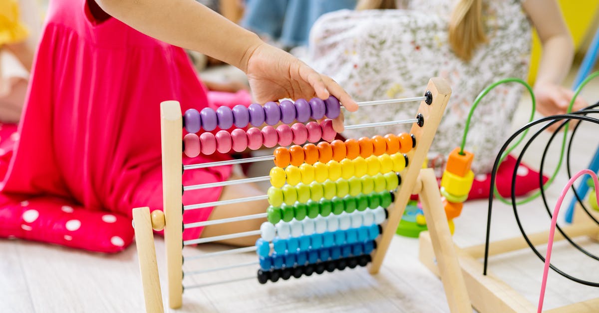 When to count children as guests? - Girl Holding Multi Colored Wooden Abacus