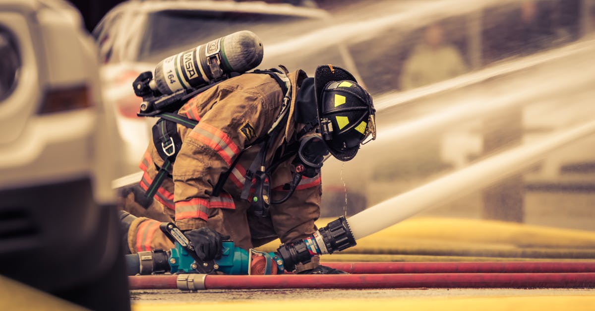 When to use the emergency brake in a train? - Firefighter Holding Hose with Water Flowing