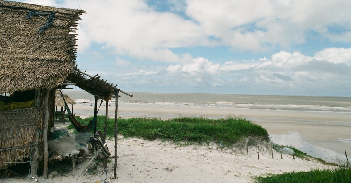 When transiting Beijing (PEK), citizens of which countries need visas? - Poor indigenous cabin with thatched roof on sandy coastline with wavy ocean in cloudy day