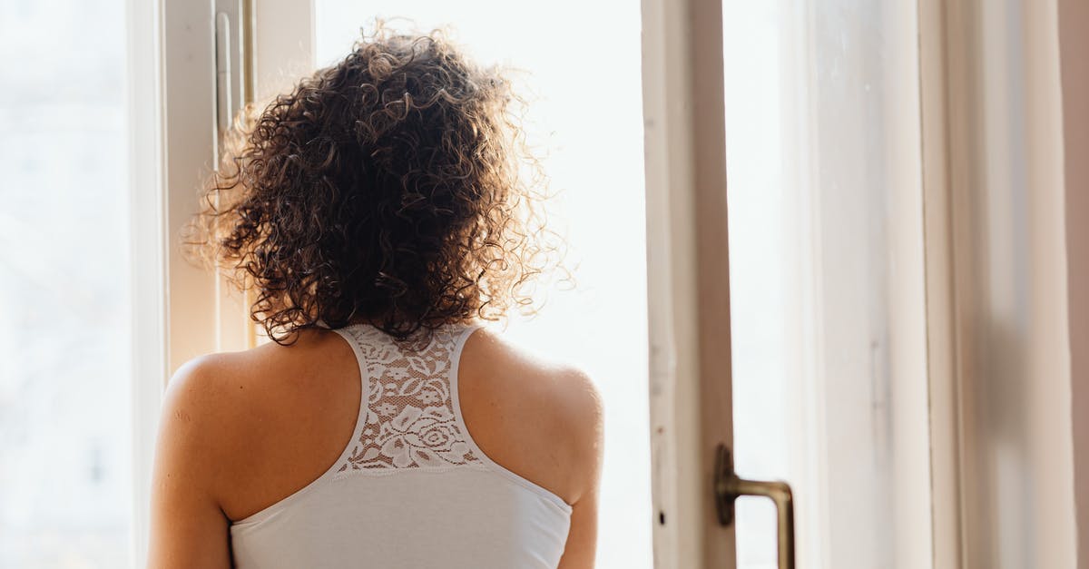 When will the Sistine Chapel open after the Papal Conclave? - Woman in White Tank Top Standing Near White Wooden Framed Glass Window