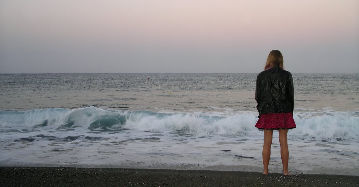 Where's this shore look out in Oregon? [closed] - Back View Photo of Barefoot Woman in Black Leather Jacket and Standing by the Beach Looking at the Horizon