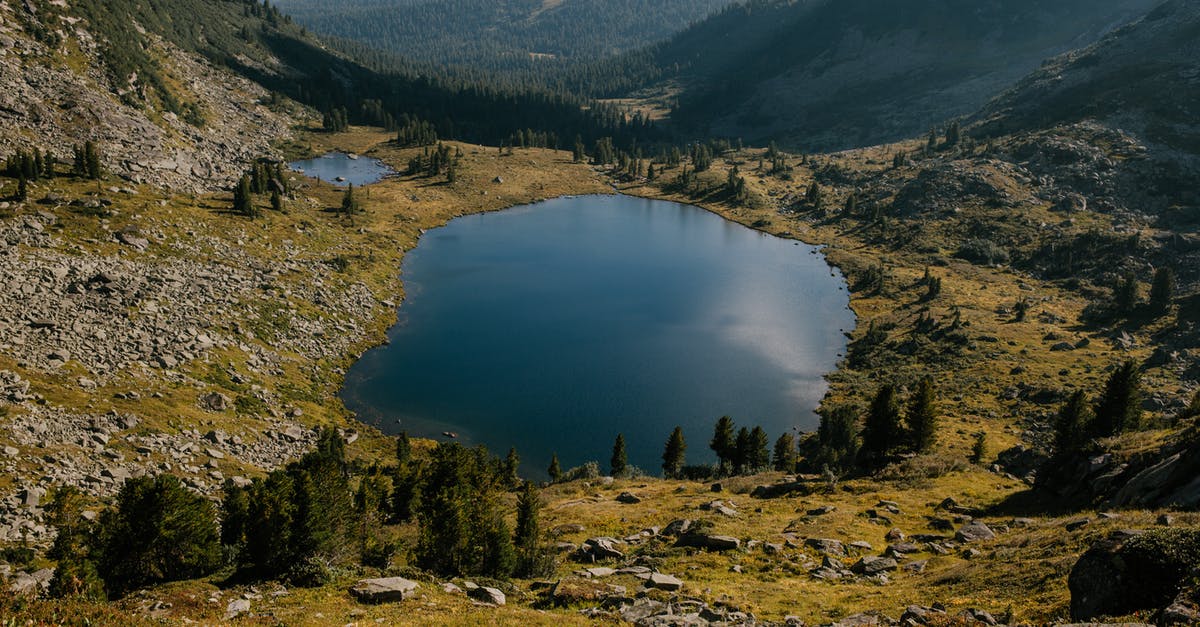 Where's this verdant ridge? - Clear lake surrounded with green trees and grass on hills