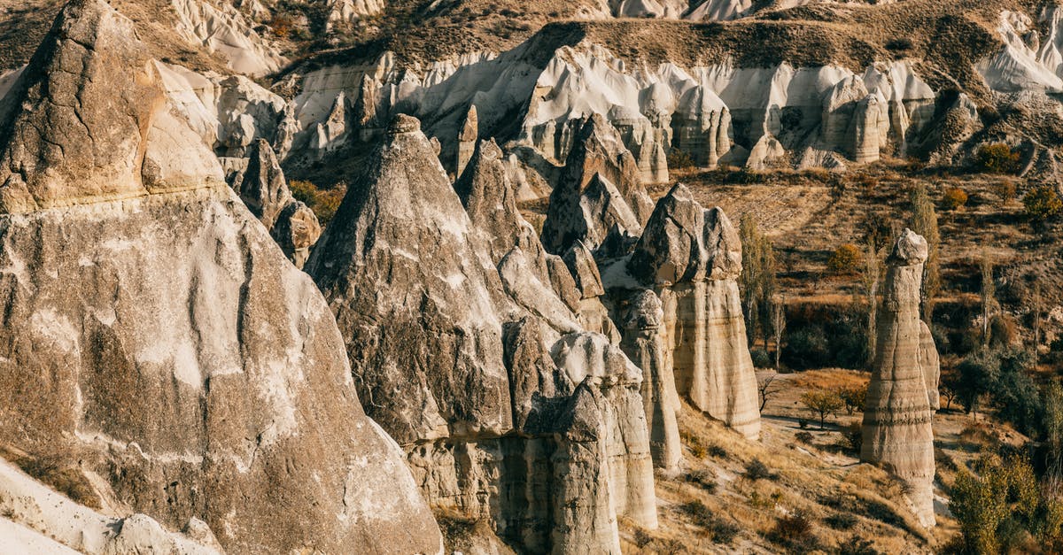 Where are these unusual rock formations rising from the water? - Fairy chimneys in rocky terrain on sunny day