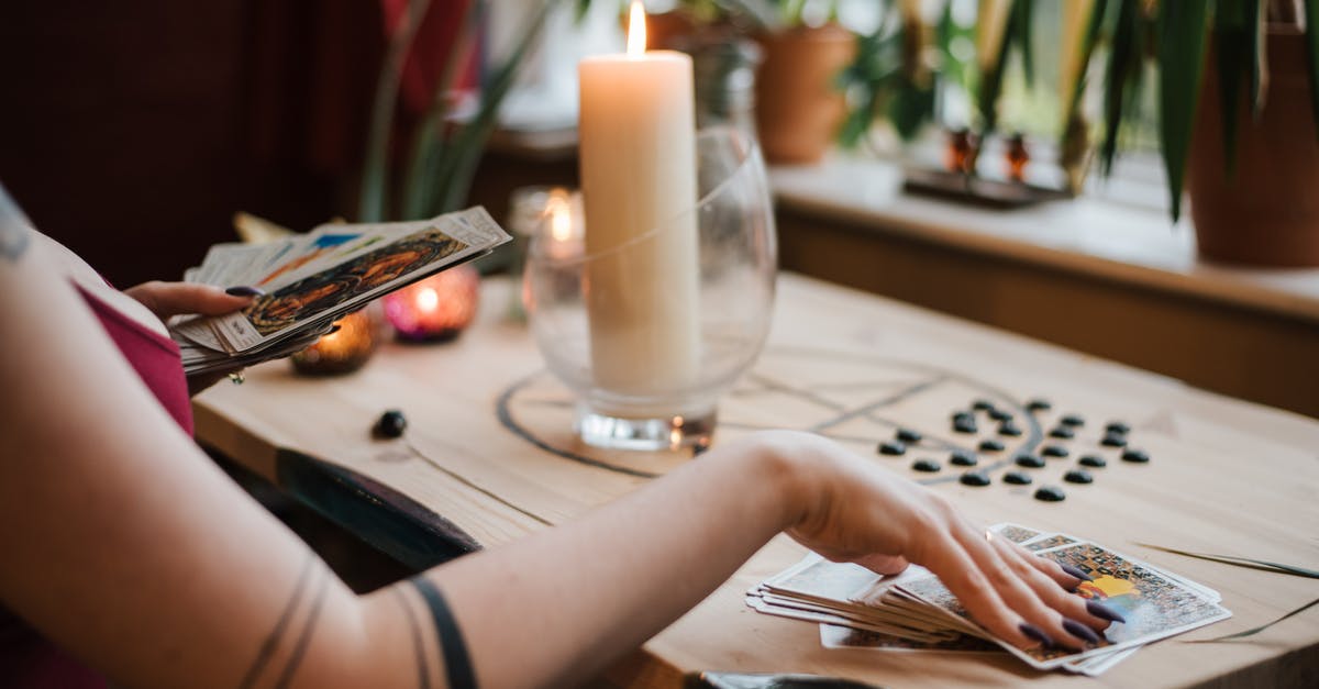 Where can I get an anonymous Rav Kav card issued? - Crop unrecognizable fortune teller predicting fate with tarot cards near shiny candle at home