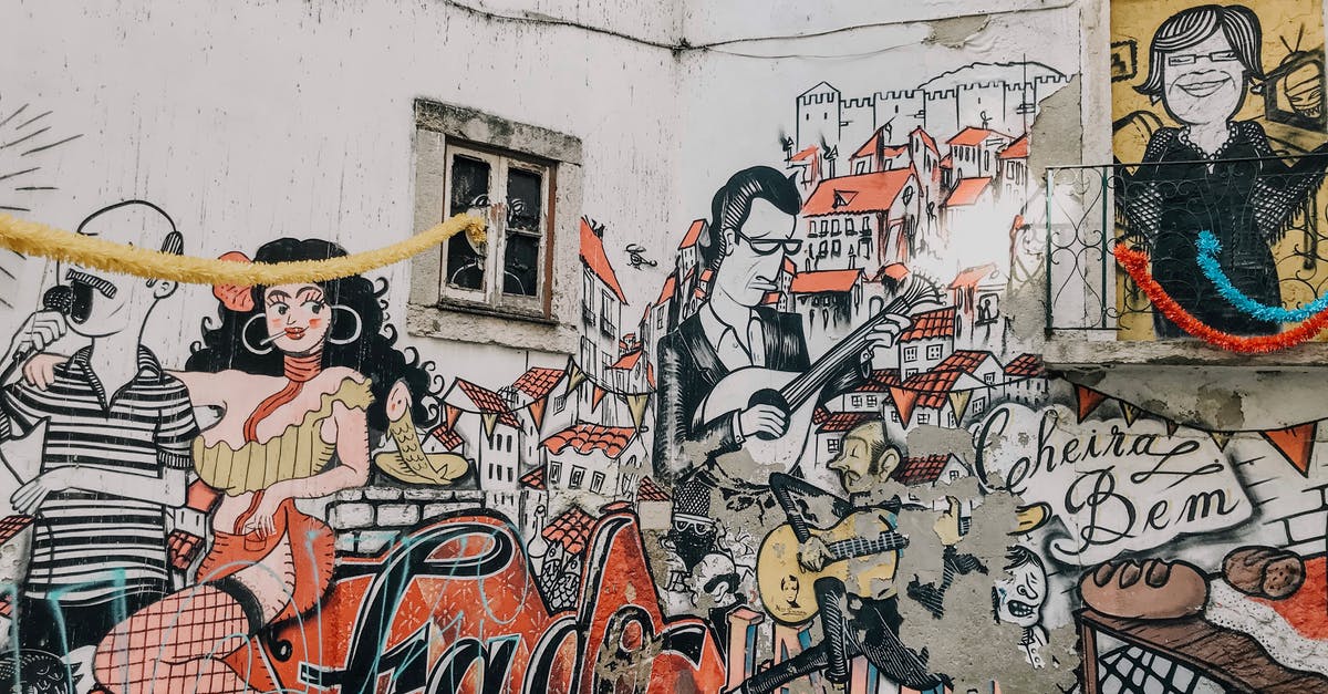 Where can I listen to authentic Fado in Lisbon? - Graffiti on White Concrete Wall