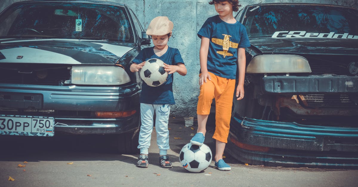 Where can I rent 90's sports cars in Japan? - Two Boys Playing Soccer Ball Beside Cars