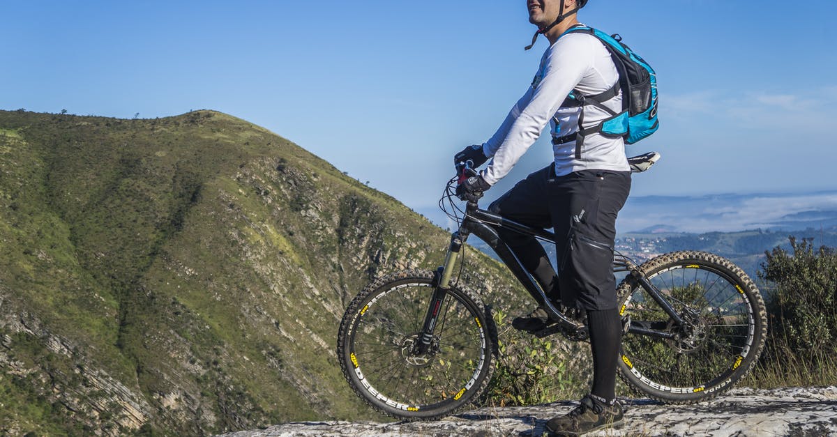 Where can I rent a decent mountain bike in Zürich? - Man With White Shirt Riding Abicycle on a Mountain