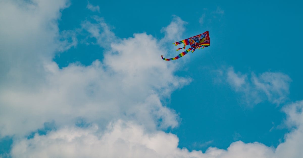 Where can I rent and fly a kite in Singapore? - From below scenery of multicolored bright kite soaring in peaceful blue sky