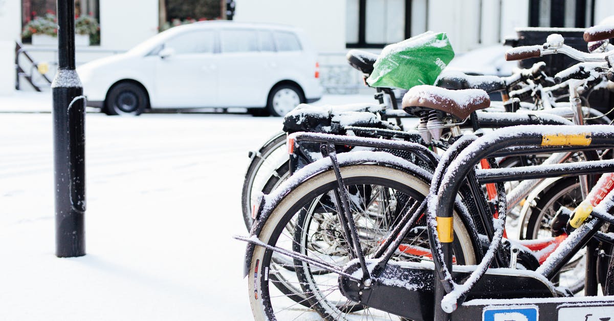 Where can I rent bikes in Arnhem, The Netherlands? - Modern bicycles parked on street covered with snow on winter day in city district