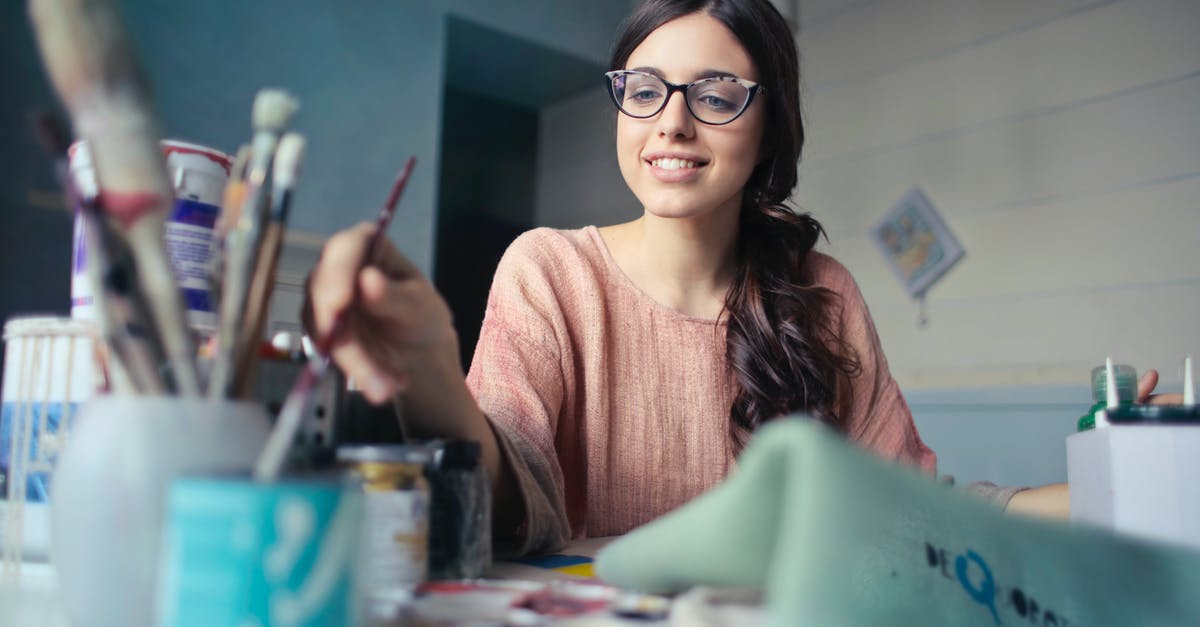 Where can I socialize with young Japanese people? - Woman in Brown Long-sleeved Shirt Wearing Eyeglasses Holding Paint Brush