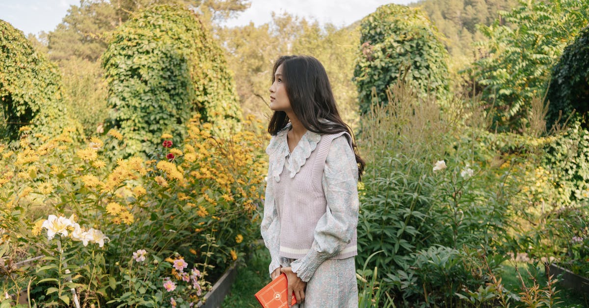 Where can I socialize with young Japanese people? - A Young Woman Holding a Book while Standing in a Garden