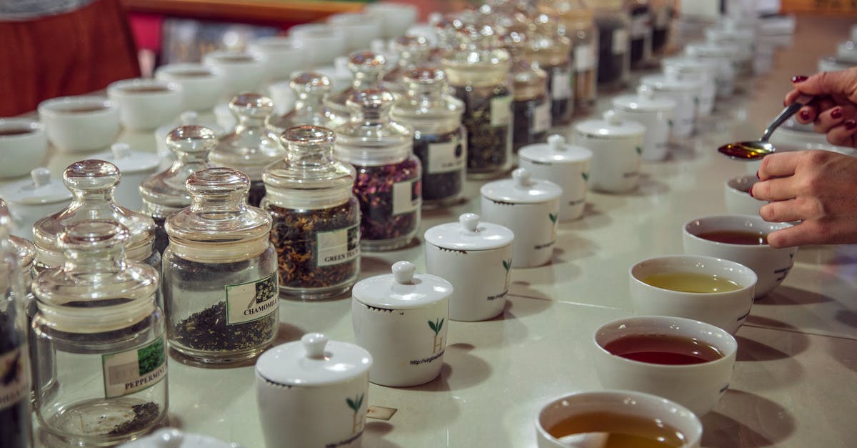 Where can I try a locally brewed Porter in London? - Crop anonymous female with teaspoon standing near table with assorted aromatic teas served for tea tasting session