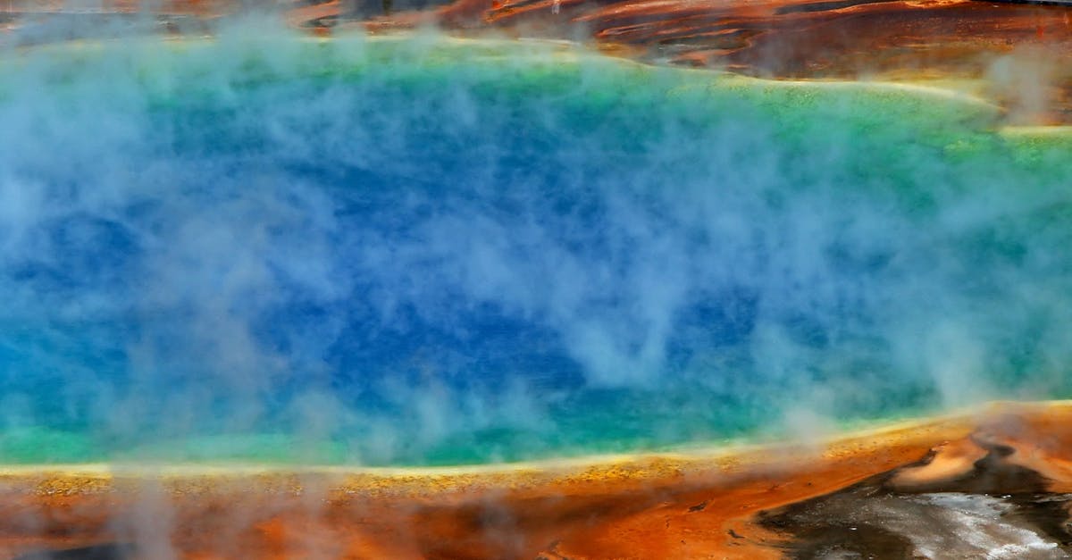 Where can one experience hot springs in Yellowstone National Park? - Lake With White Steam