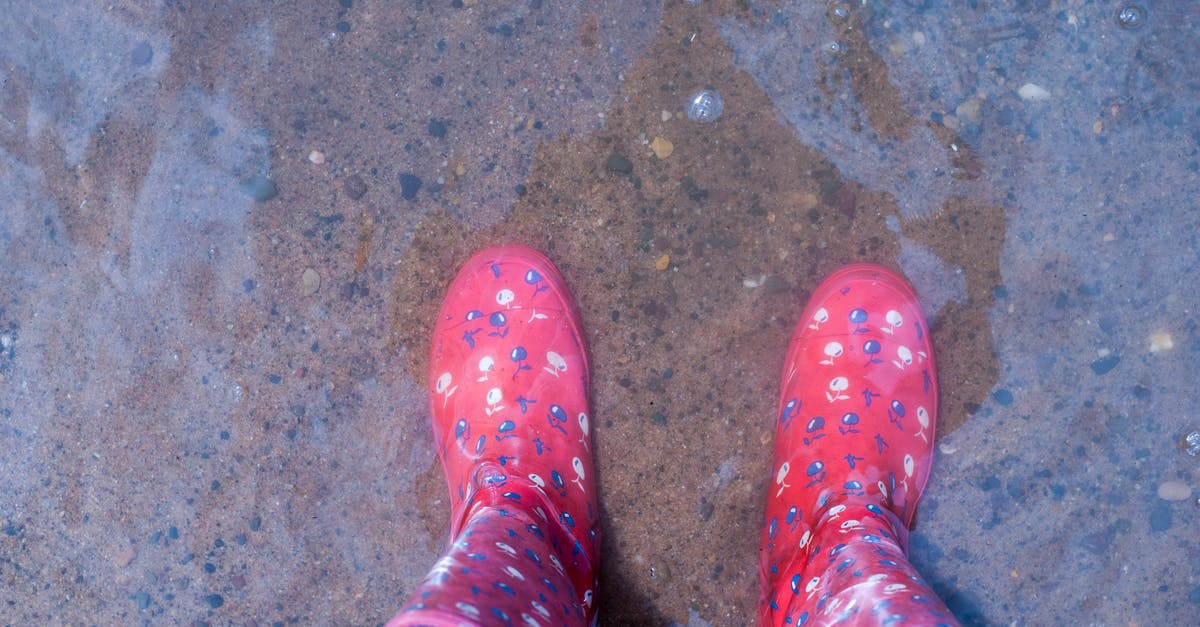 Where can one rent rain boots in Uyuni? - Person Wearing Pink Knee-high Rain Boots Standing on Brown Floor