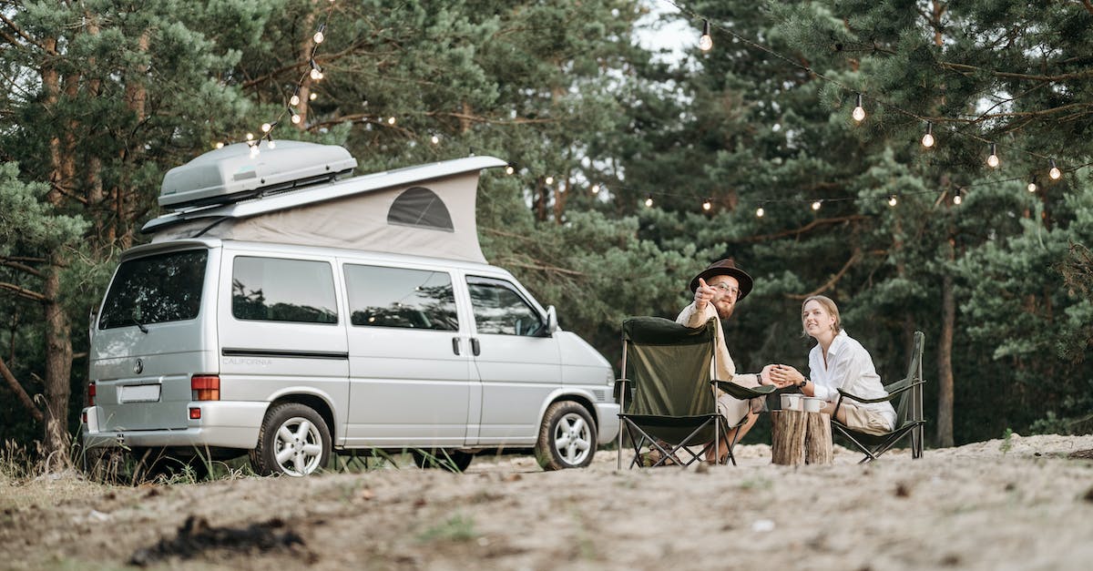 Where can you park a camper in Munich? - Man and Woman Sitting on Chairs Near White Van