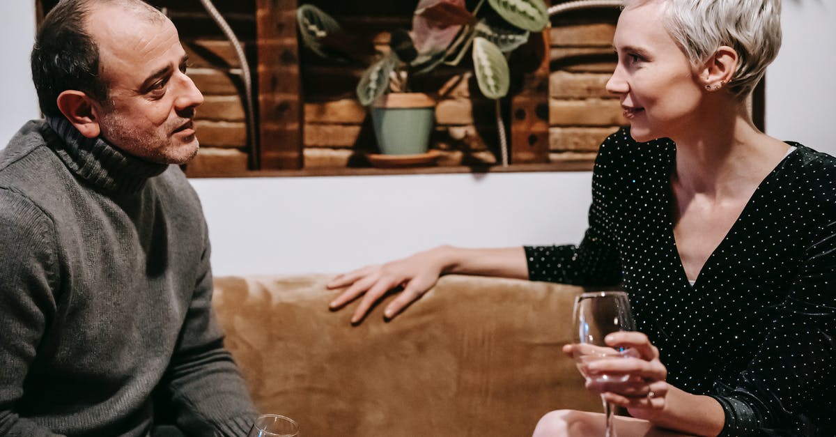 Where do I find short-term house share offers in Auckland? - Side view of couple sitting on sofa with glasses of drink and having conversation