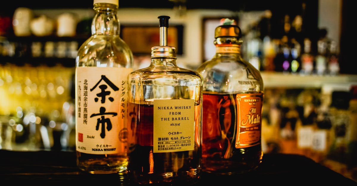 Where in Japan can I buy ear-wax dissolving liquids? - Three Assorted Liquor Bottles on Table