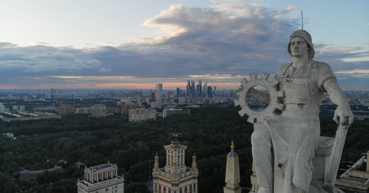 Where in Moscow is/was this 1980 Olympics logo sculpture located? - White Concrete Statue Near City Buildings