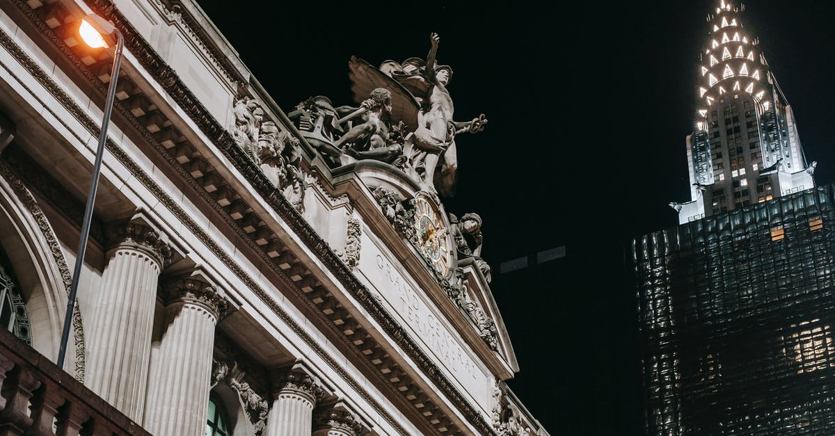 Where in the US is this statue located? [closed] - Historic stone building near modern glass tower at night