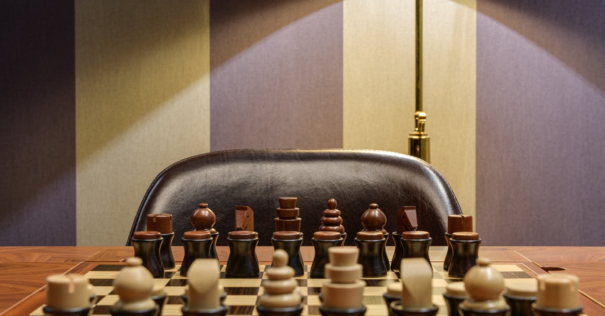 Where is exactly the place of Winterfell from Game of Thrones? - Interior of room with wooden table with chessboard near chair and light lamp near wall