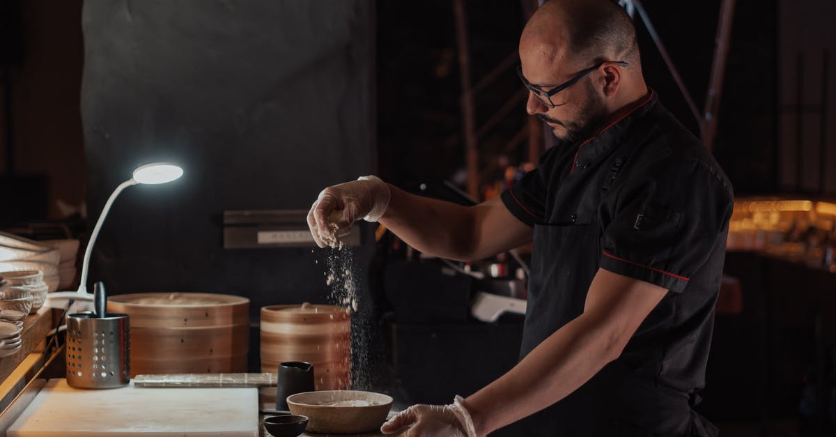 Where is the Bamboo restaurant located in Kyoto? - Man in Black Chef Uniform Sprinkling Flour on Ceramic Bowl