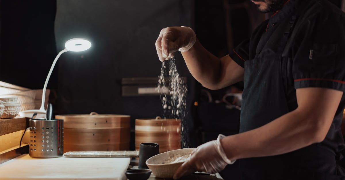 Where is the Bamboo restaurant located in Kyoto? - Man in Black Chef Shirt Sprinkling Flour Above Ceramic Bowl