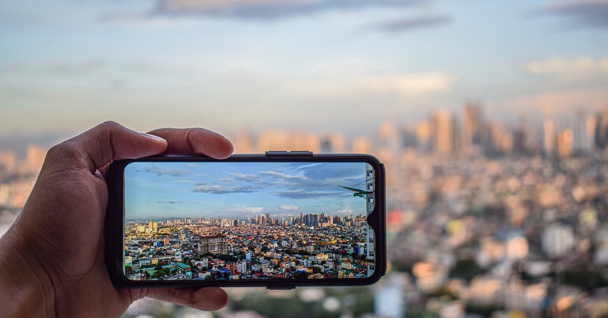 Where is the cityscape in this recent photo, probably in Malaysia? - Hand Taking Photo of City