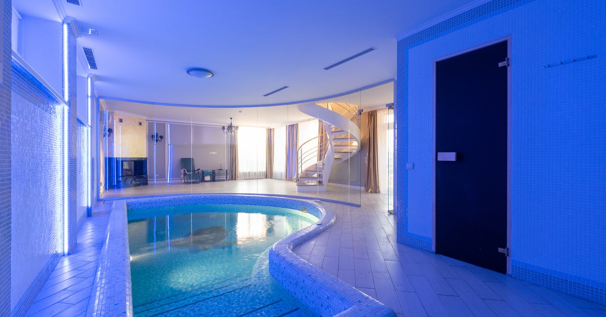 Where is this blue tile in the New York subway? - Swimming pool with clear water placed in spacious room at wall with blue illumination and staircase in contemporary luxury house