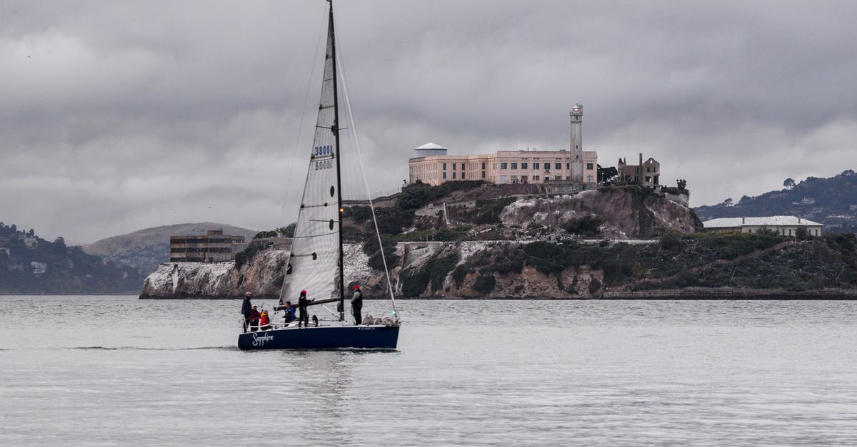 Where is this castle? - White and Blue Boat on Sea Near Brown Concrete Building Under Gray Sky