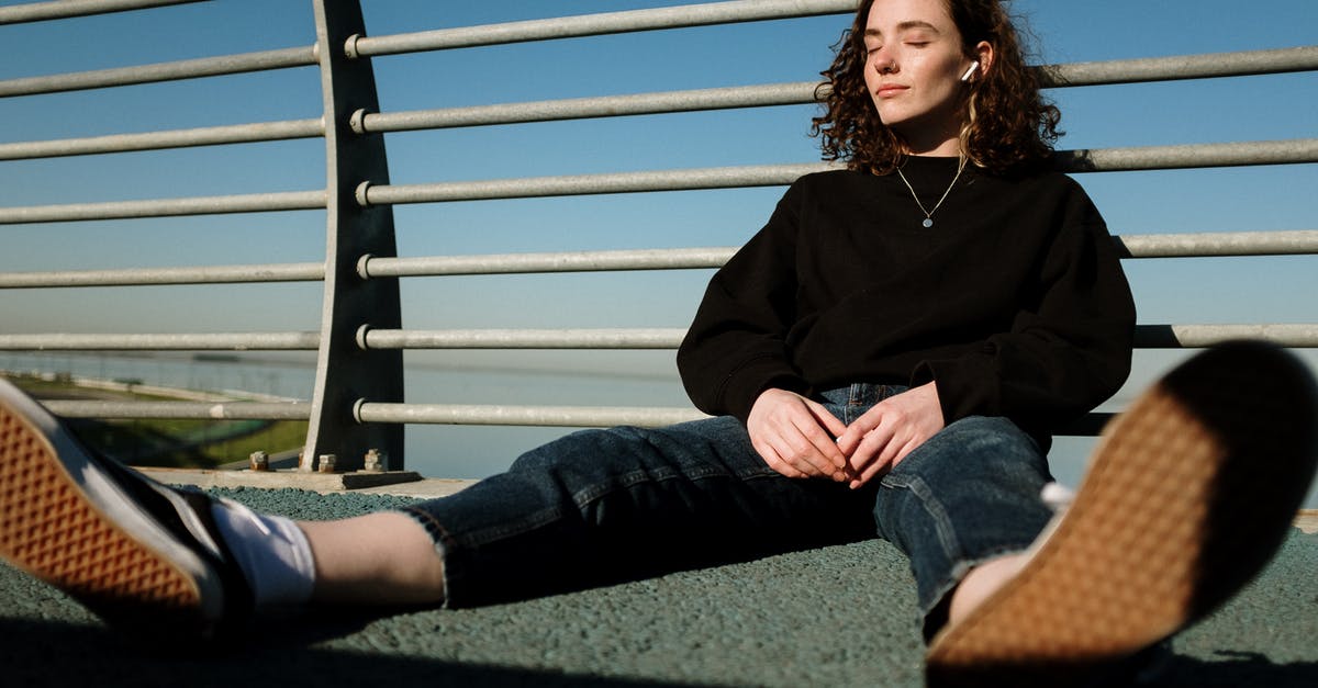 Where is this fence boardwalk located in Victoria, BC? - Woman in Black Long Sleeve Shirt and Blue Denim Jeans Sitting on Green Grass Field during