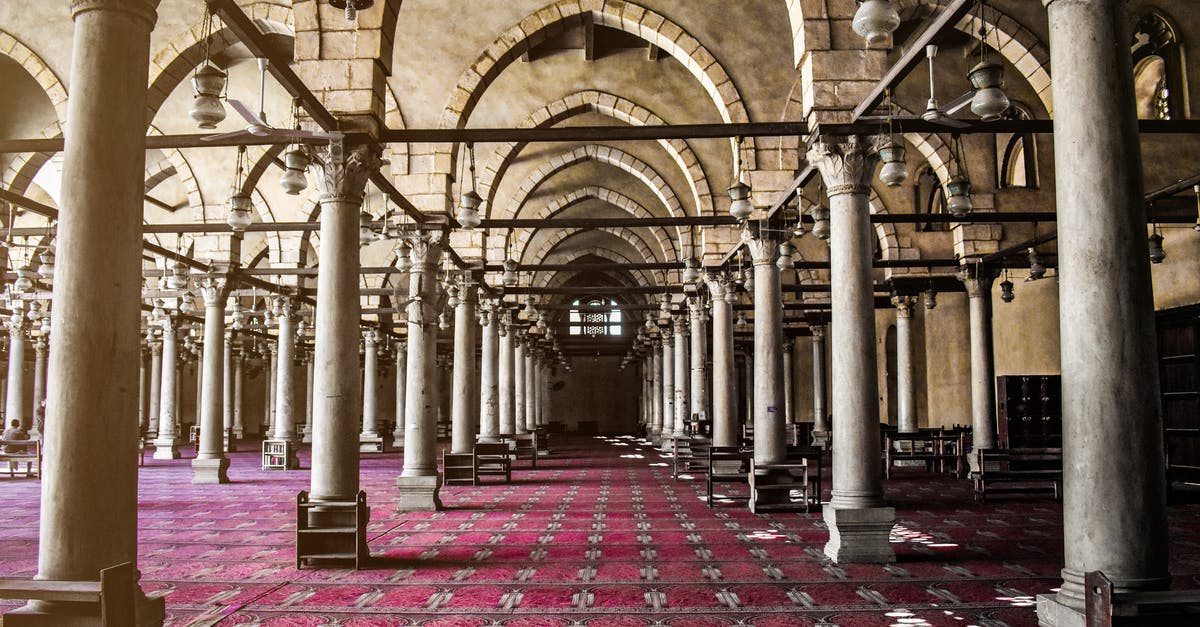 Where is this Indian-style palace with a large pool? - Interior design of large passage covered with ornamental red carpet and decorated with  arches and columns