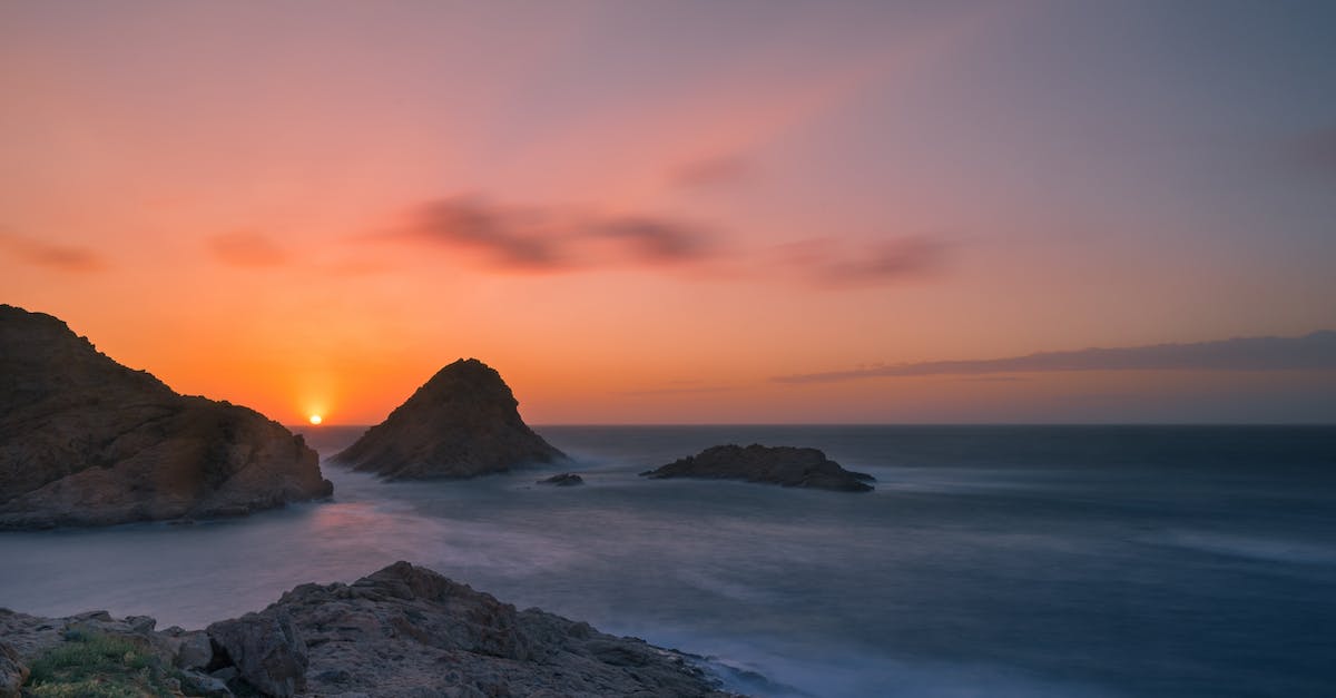 Where is this mountain with very striking bright colors? - Body of Water during Sunset