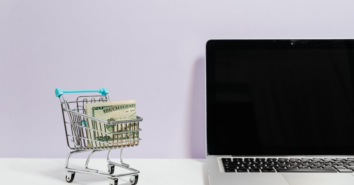 Where should I go in Yangon to buy computer parts / electronics? - Macbook Pro on White Table Beside a Miniature Shopping Cart With Money