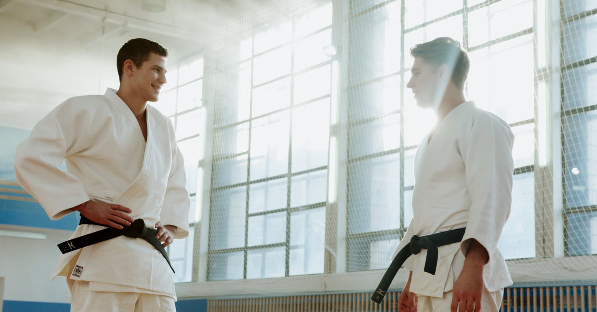 Where to buy a judo uniform (judogi) in Tokyo - Men Wearing White Uniform with Black Belt Standing Face to Face while Smiling at Each Other