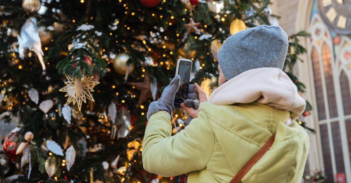 Where to buy winter clothes in Rome , Italy? [closed] - Unrecognizable Female Person in Winter Clothes Making Photo of Decorated Christmas Tree